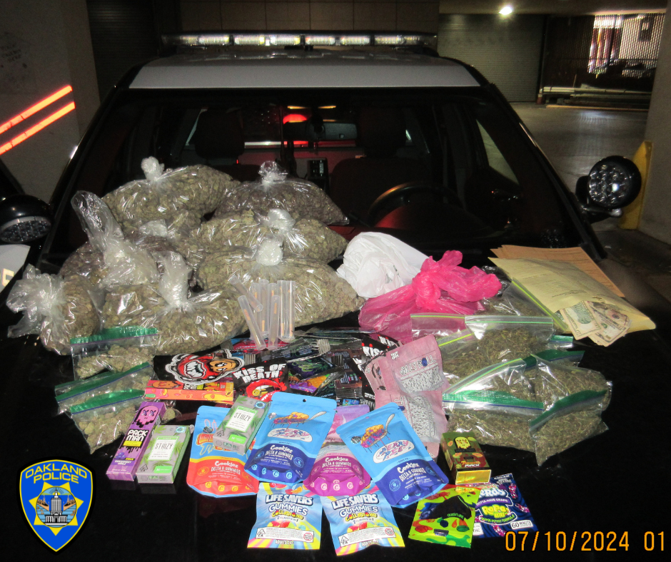 seized Psilocybin “magic” mushroom candy bars, nearly 10 pounds of marijuana bud, close to 20 pounds of suspected THC products, and cartons of prohibited and unlawful tobacco products sitting on a police car