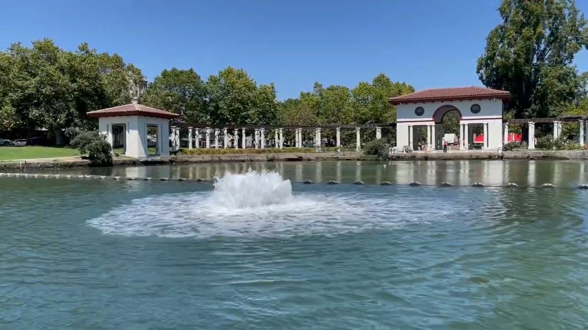 Photo of a fountain spraying water at Lake Merritt with the Pergola in the background