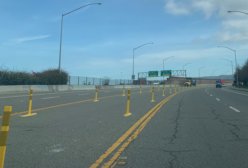 Photo of Frontage Road showing median, which has vertical posts along both outside edges of the median