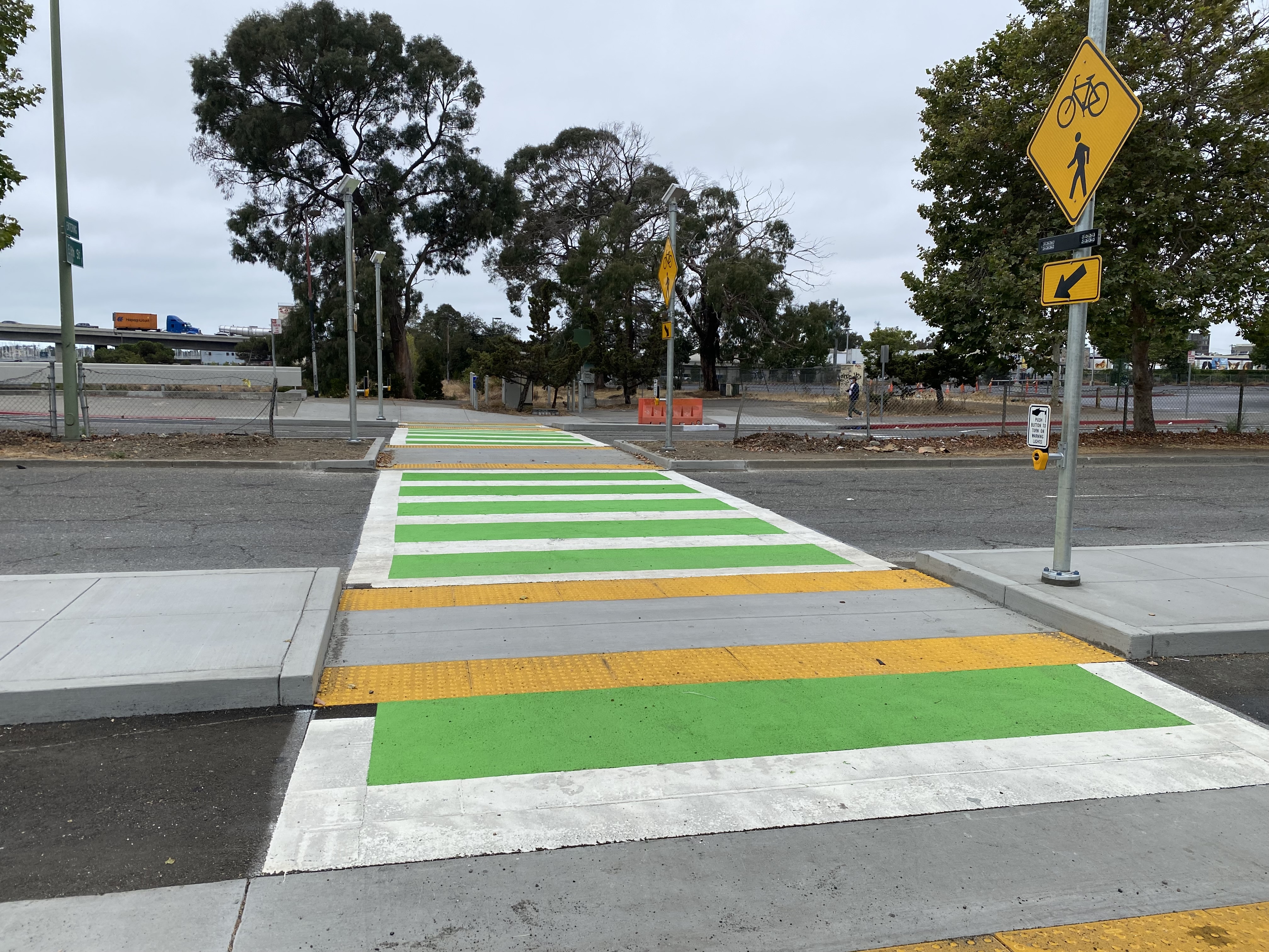 A green white and yellow pedestrian crossing.