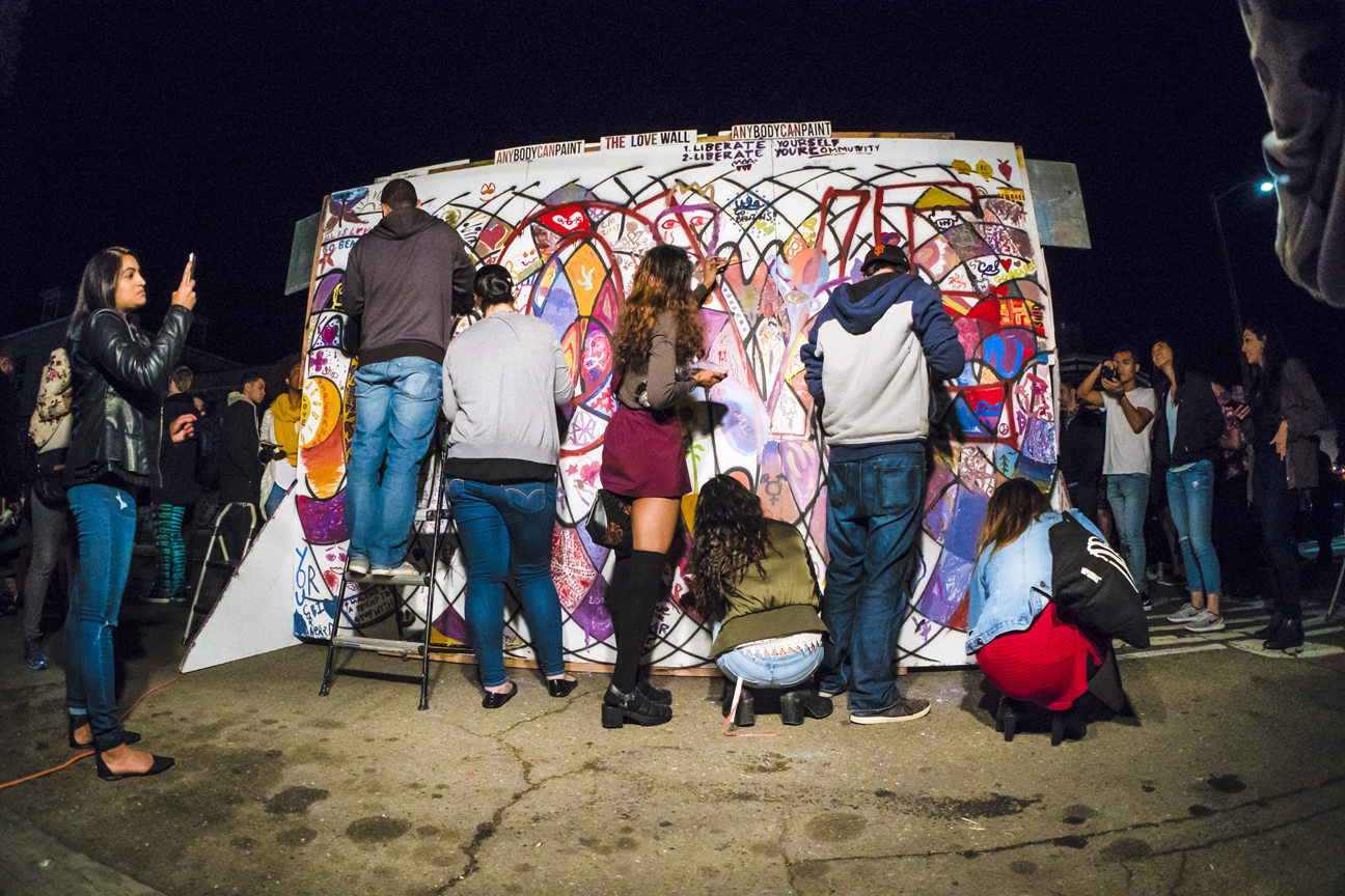 People painting on a mural at a night festival