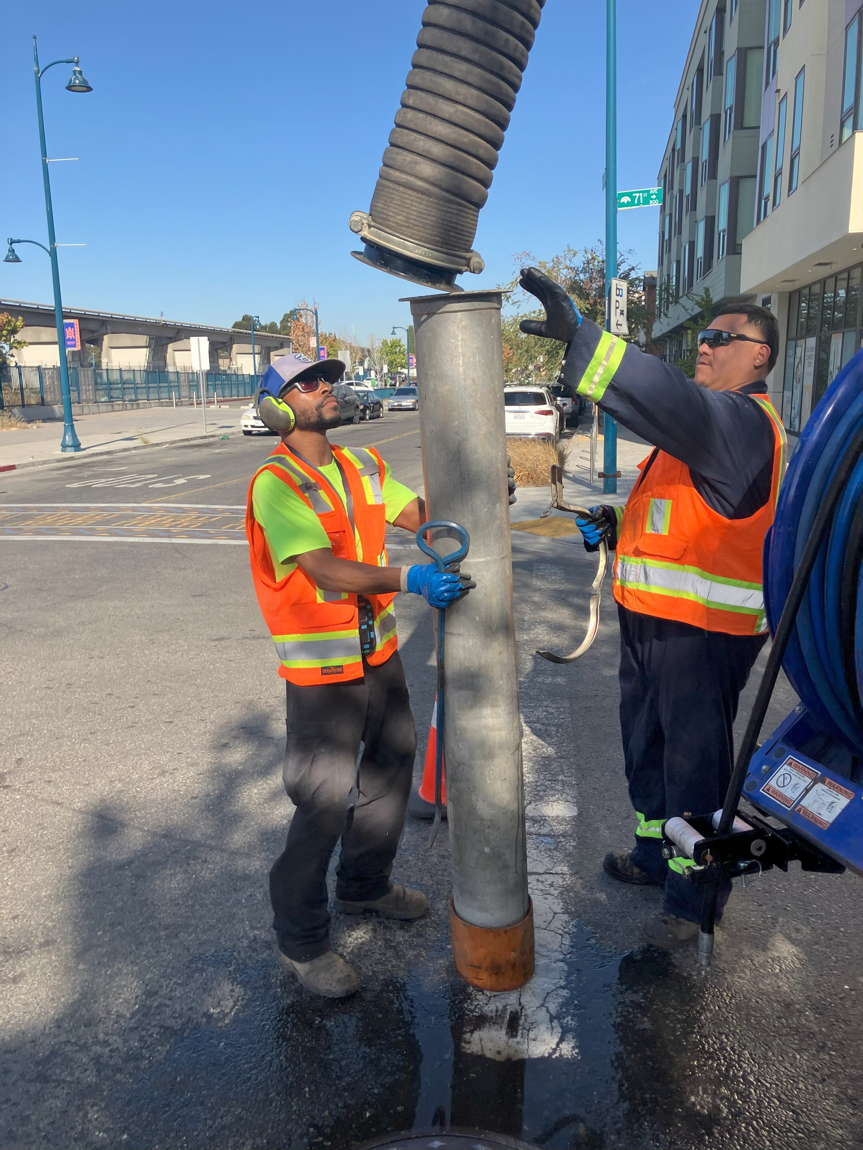 Two City workers conducting storm drain maintenance