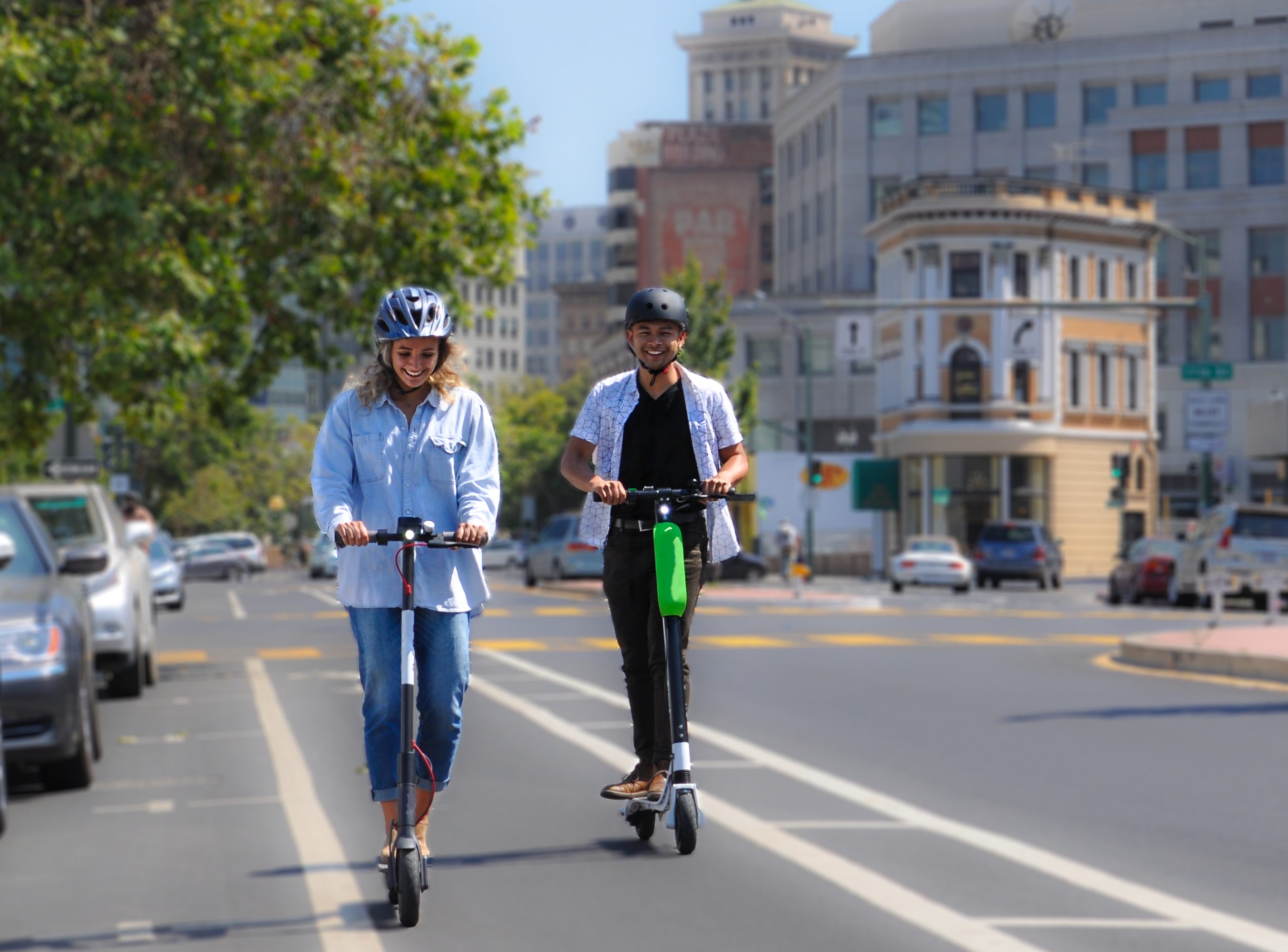 Two people riding e-scooters